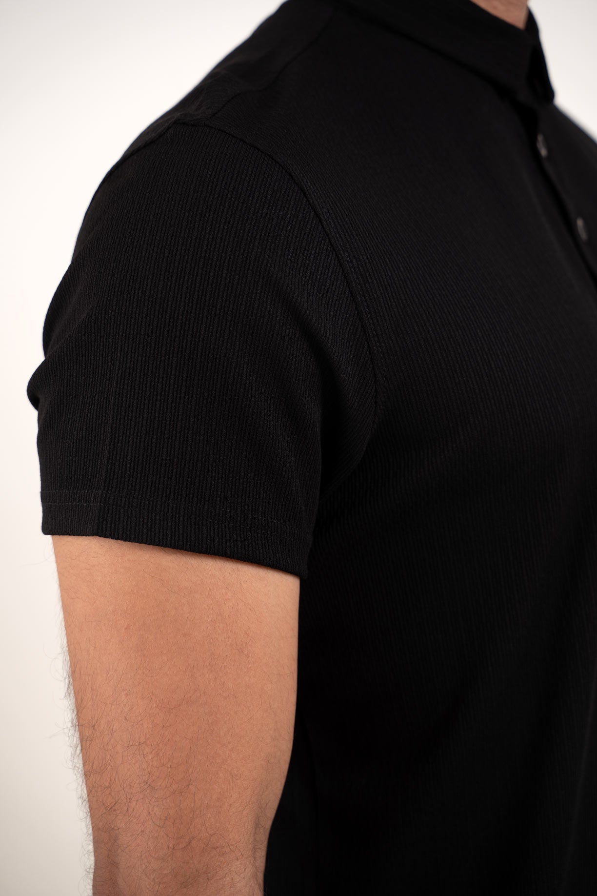 Black polo tshirt closeup of hand stich