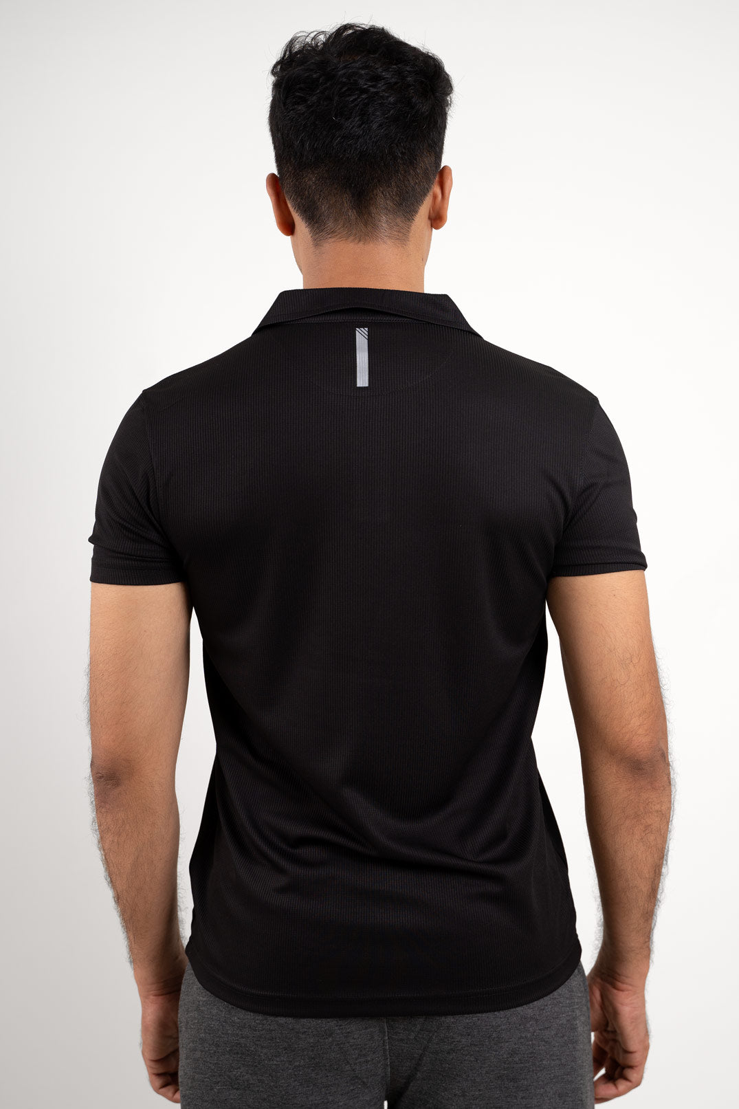 Back view of the active black polo t-shirt, showcasing its minimalist and modern look