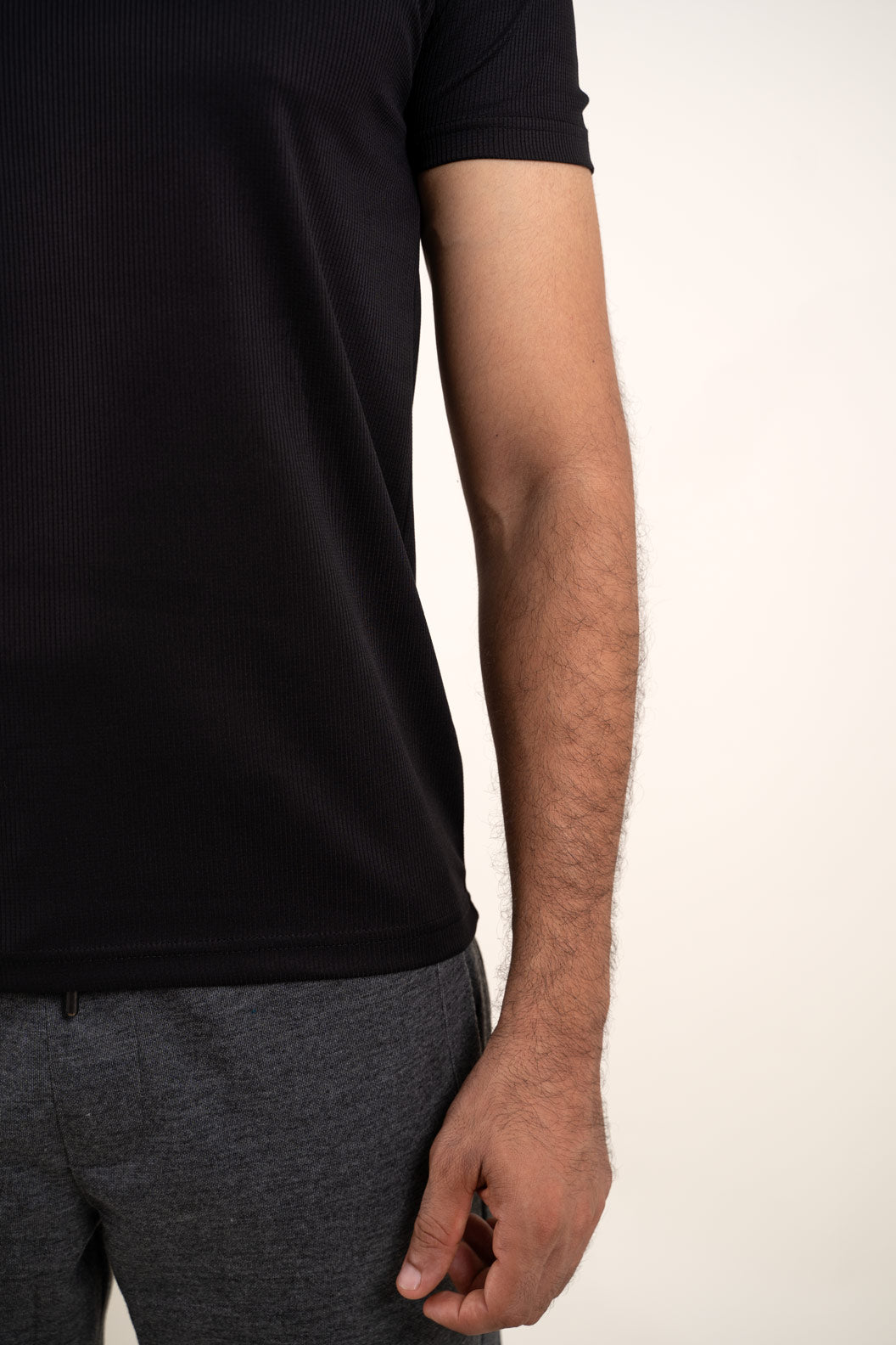 Close-up shot of the fabric of the active black polo t-shirt, revealing its moisture-wicking and breathable texture