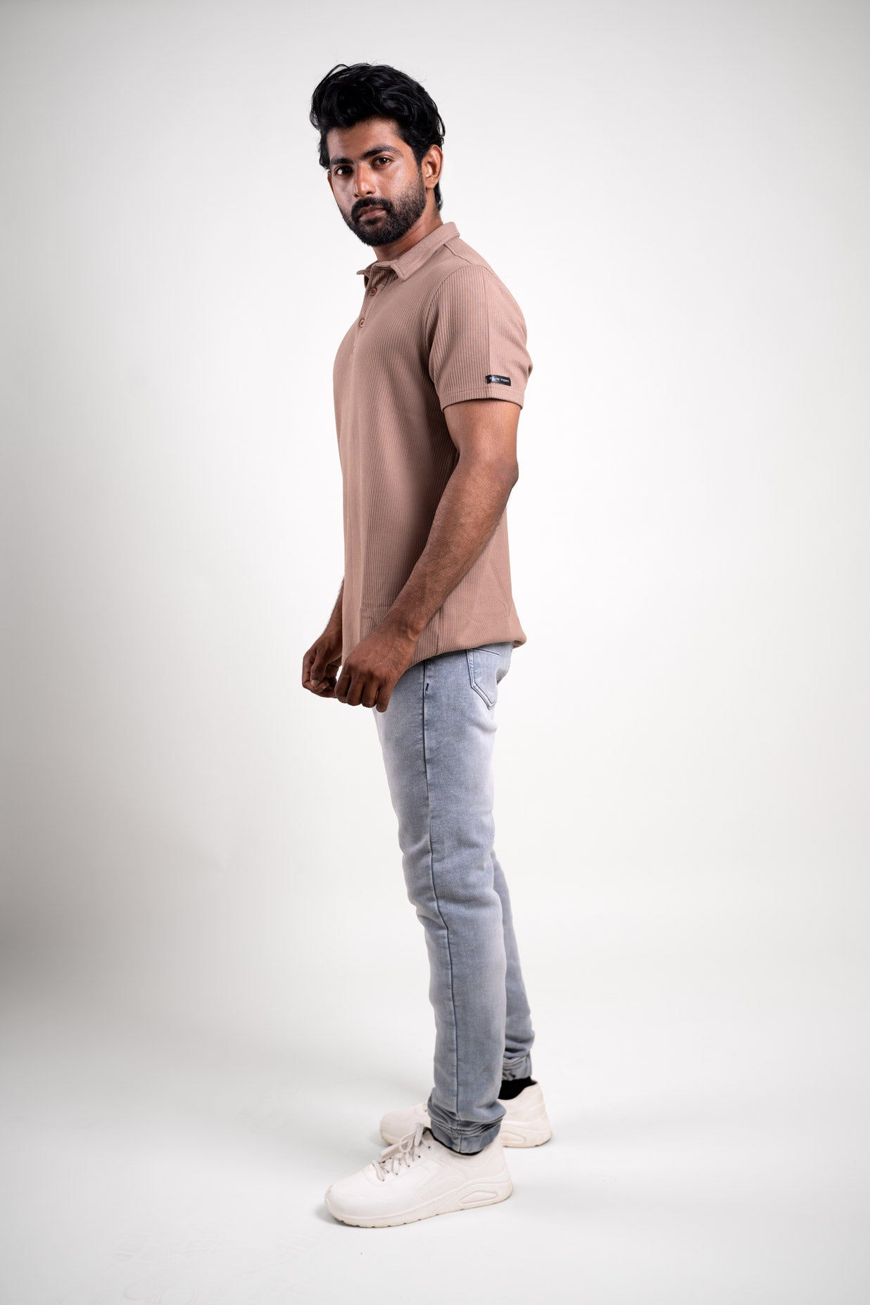 Side view of the textured light brown polo t-shirt, displaying its relaxed fit and laid-back charm