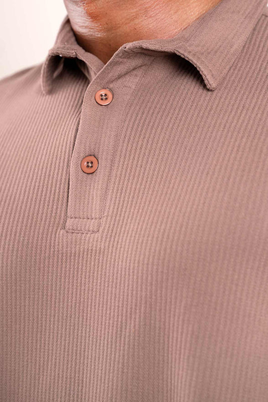 Close-up shot of the fabric texture on the light brown polo t-shirt, revealing its plush and luxurious feel.