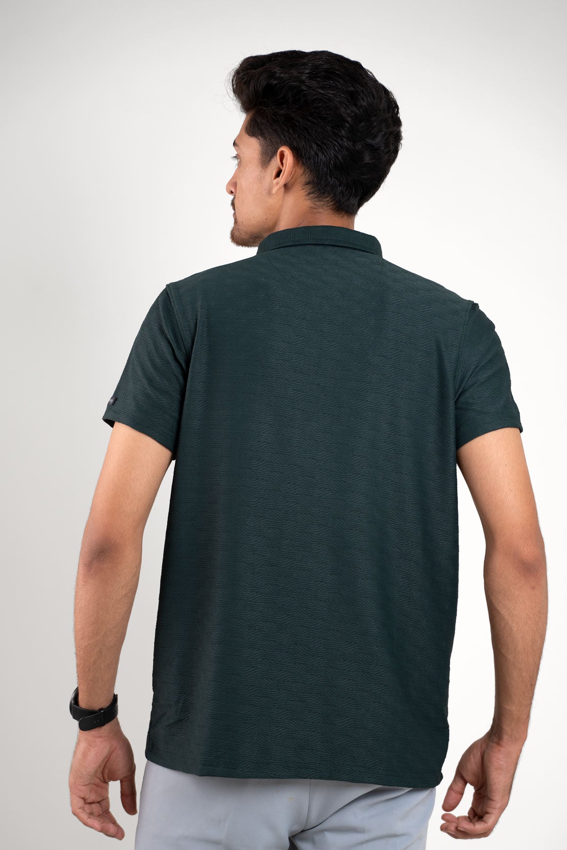 Man in green polo t-shirt with short sleeves, back view