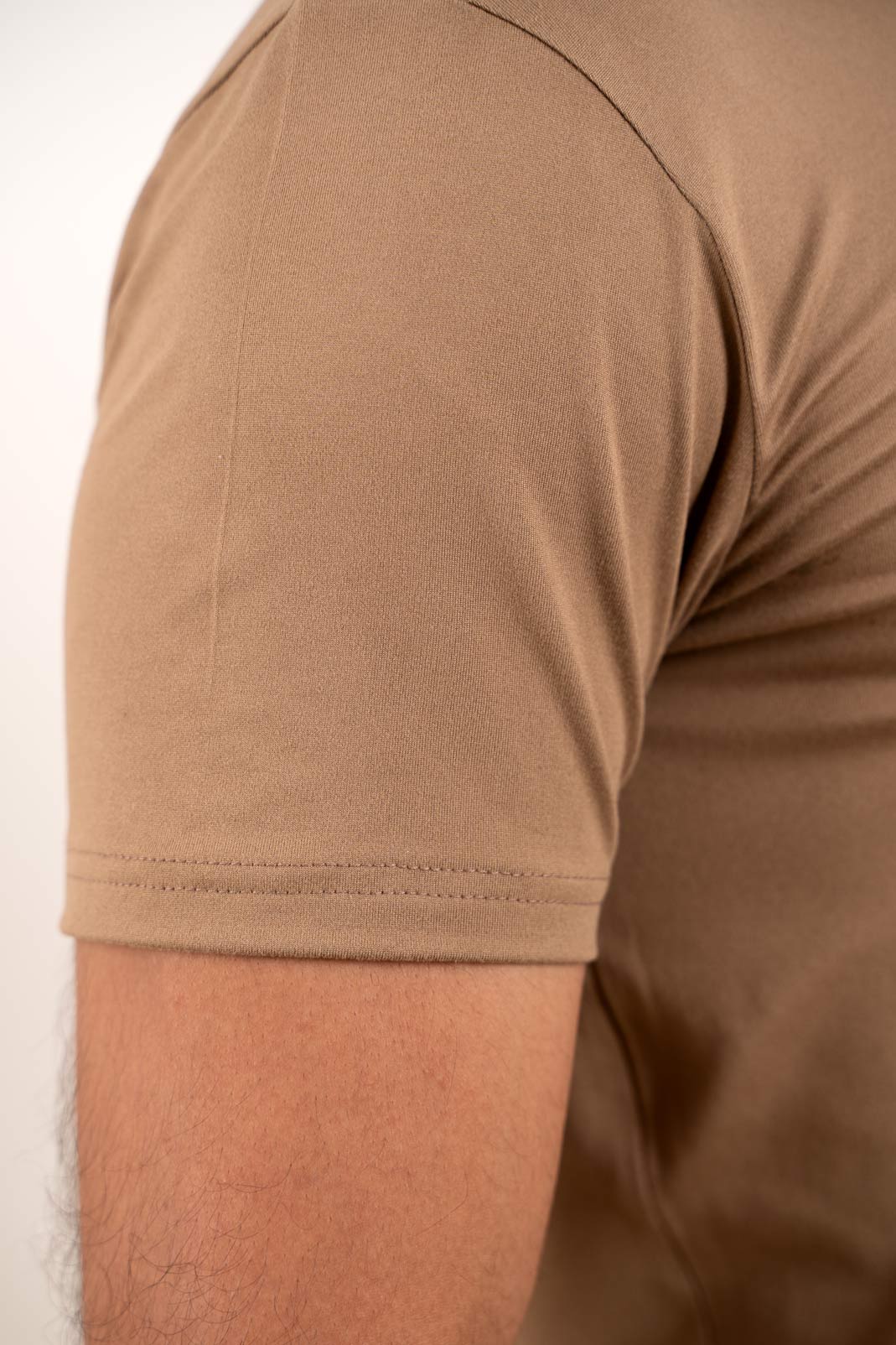 Close-up of the stitching and hem of the beige Henley t-shirt, highlighting its high-quality construction