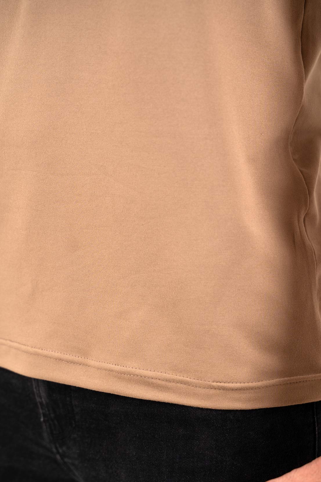 Detailed view of the buttoned neckline on the beige Henley t-shirt, emphasizing its craftsmanship