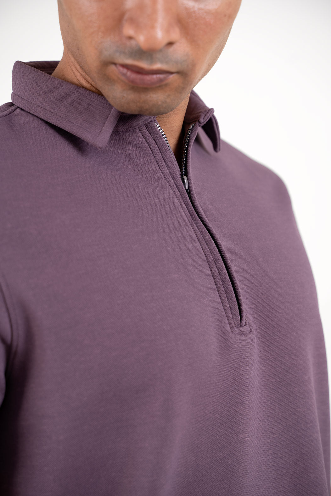 Close-up shot of the zipper collar on the lavender polo shirt, showcasing its innovative design and quality craftsmanship