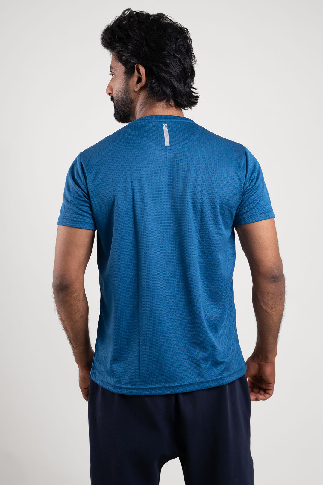 Back view of the active blue crew neck t-shirt, highlighting its fitted silhouette and stylish appearance