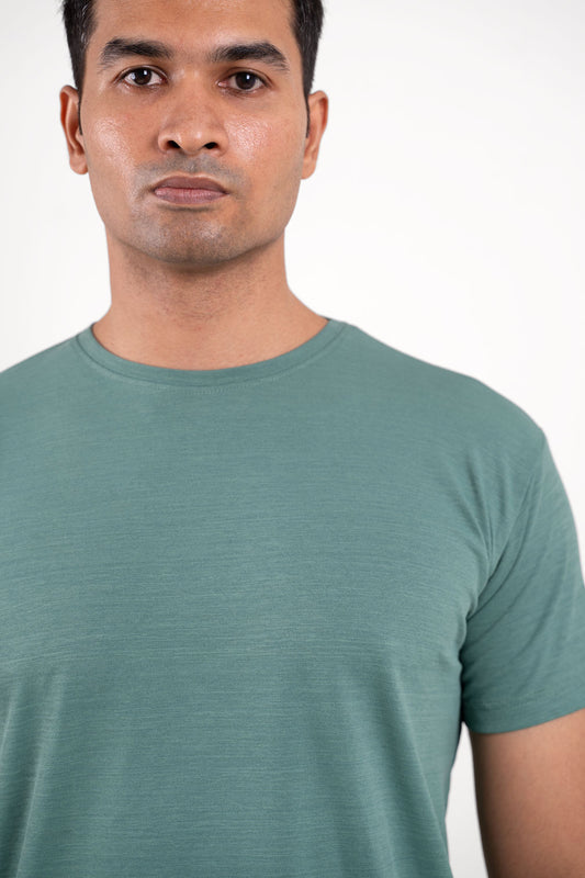 Profile view of the solid olive green crewneck tee, capturing its understated elegance and everyday versatility