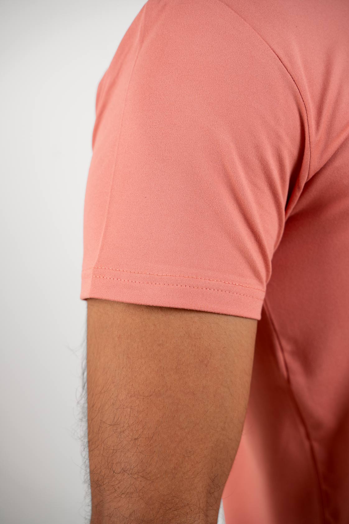 Detailed view of the buttoned neckline on the peach Henley t-shirt, emphasizing its craftsmanship
