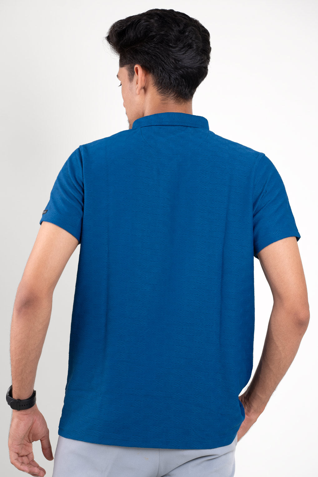 Back view of man wearing blue polo tshirt