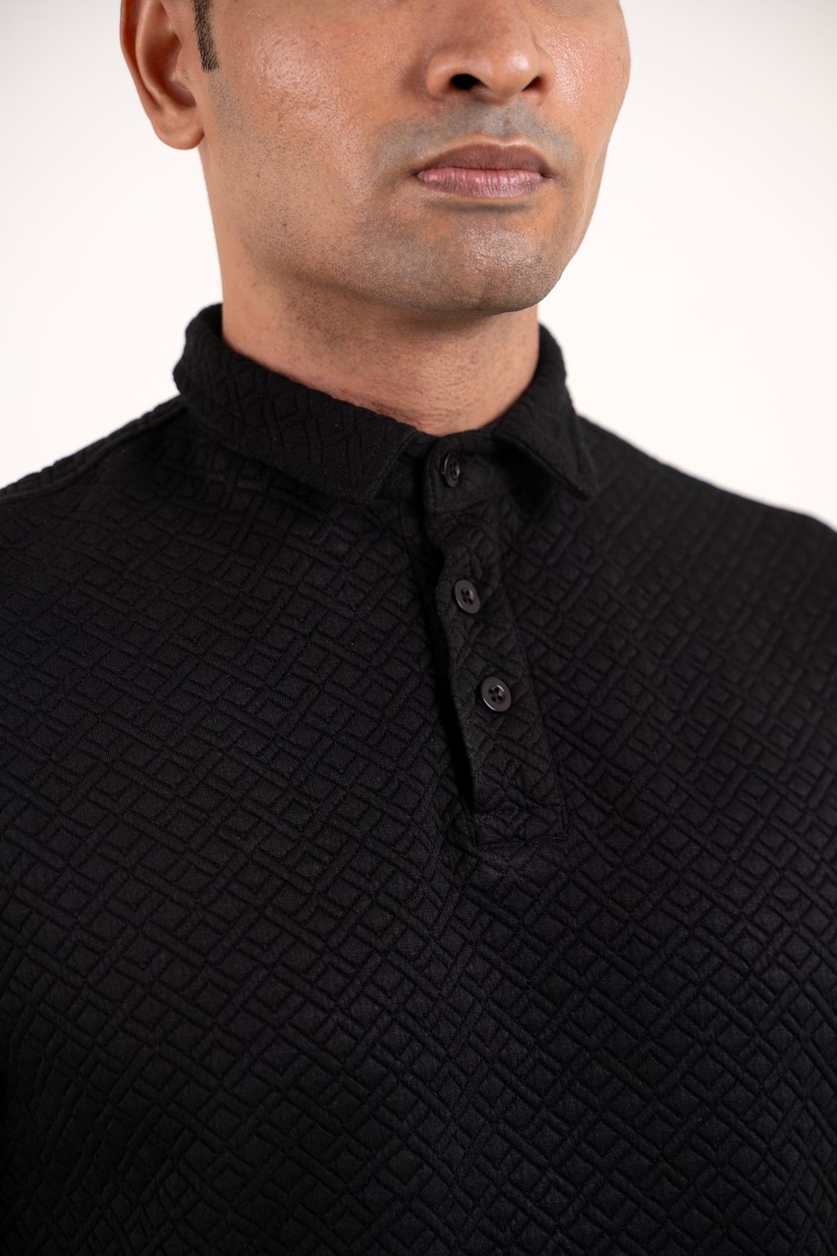 Detailed view of the collar and buttons on the black polo t-shirt, emphasizing its refined craftsmanship