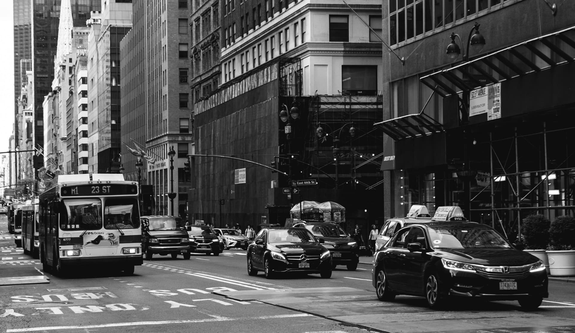 black and white image of a town with cars