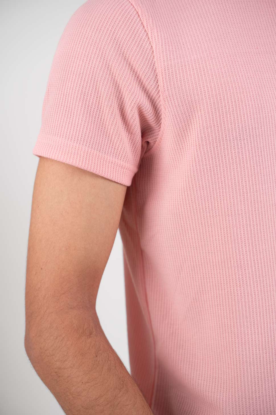 Close-up shot of the fabric of the pink polo t-shirt, revealing its smooth texture and quality