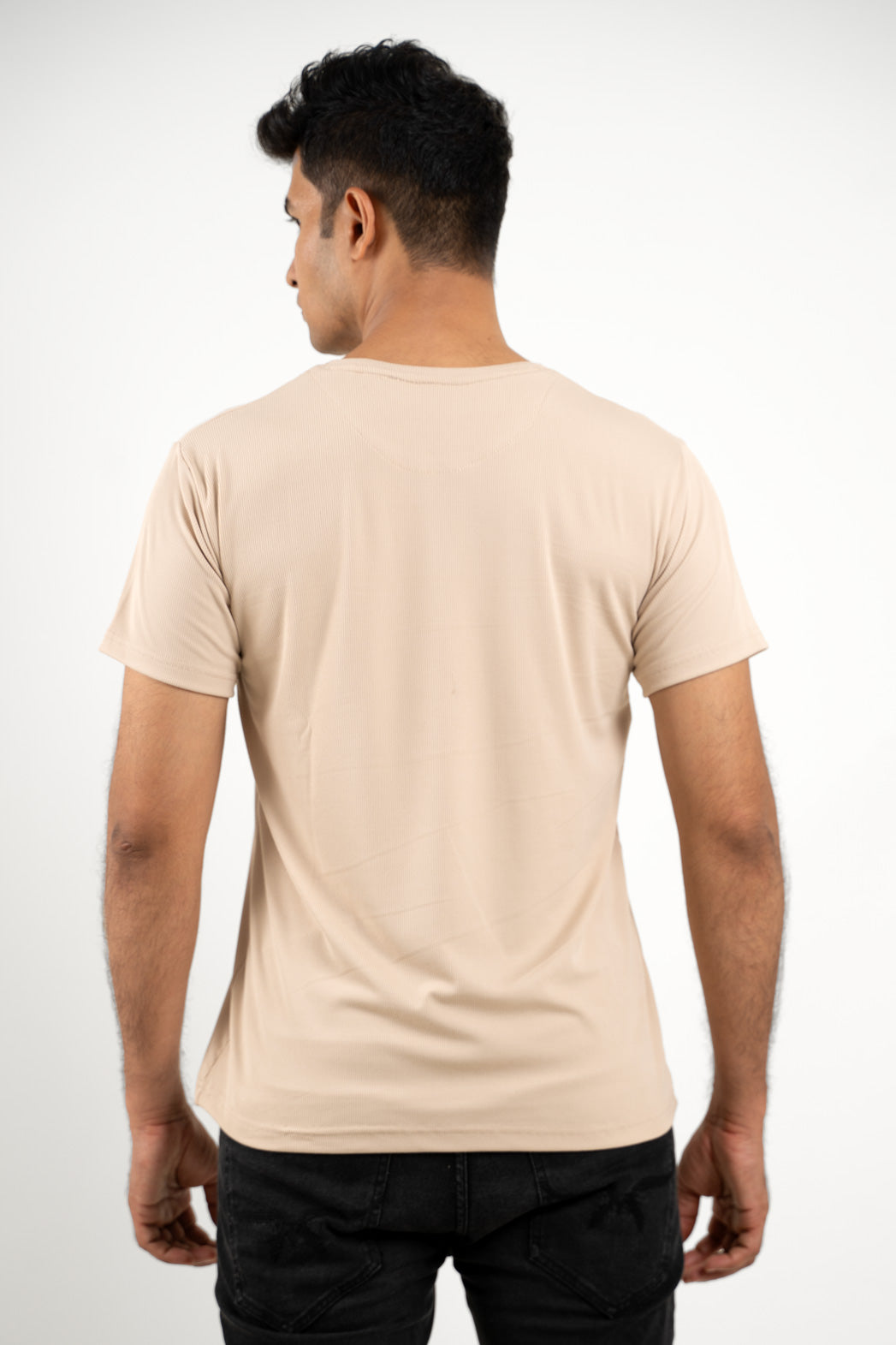 Back view of the solid beige crewneck t-shirt, emphasizing its clean lines and essential design