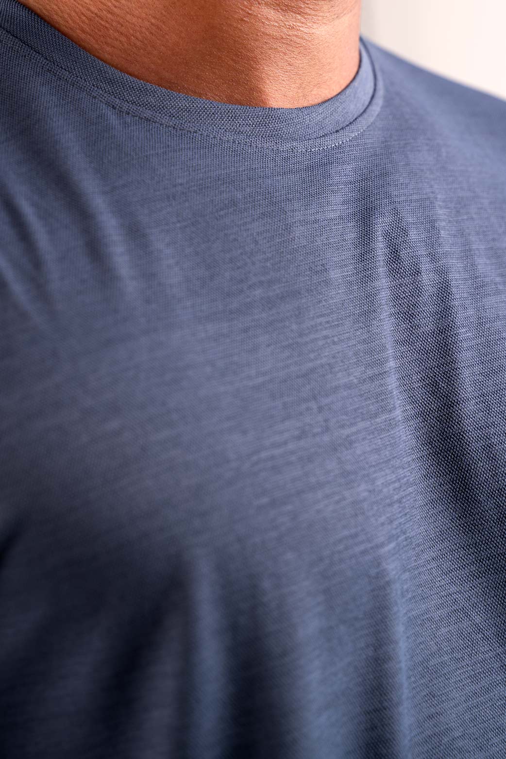 Detailed close-up of the stitching and neckline of the grey crewneck tee, showcasing its quality construction